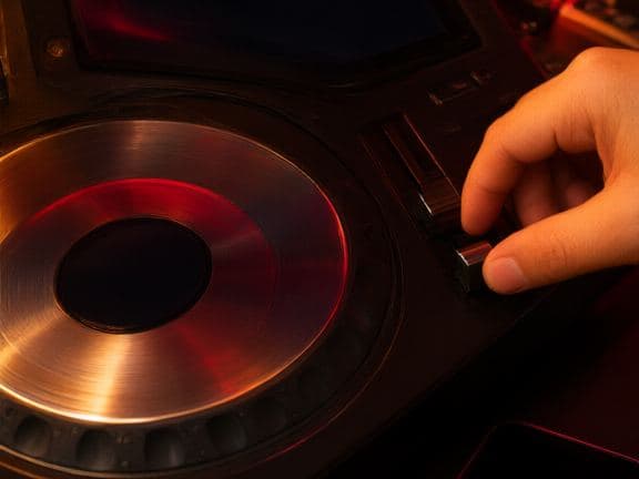 Close-up of a DJ media player jog wheel and a phone.